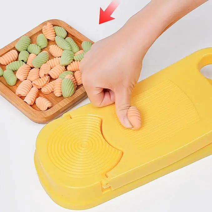 Mano usando molde para empanadas para dar forma a pasta de colores.