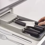 Organizador de cuchillos en cajón con varios compartimentos para almacenaje seguro.