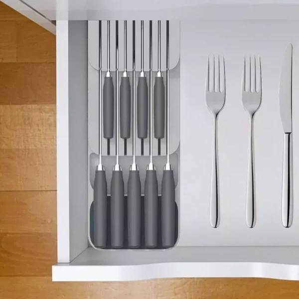 Organizador de cuchillos de cocina de metal plateado con mangos grises y cubiertos de acero inoxidable.