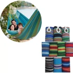 Hamaca de líneas multicolor para dos personas en la naturaleza con sacos de dormir enrollados.