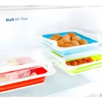 Bandejas organizadoras para nevera con huevos, tomates y embutidos.