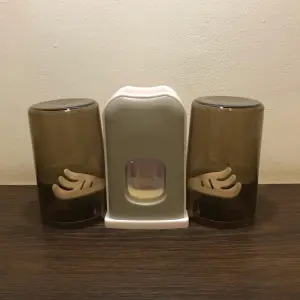 Soporte doble para cepillos de dientes y dispensador de pasta, diseño moderno.