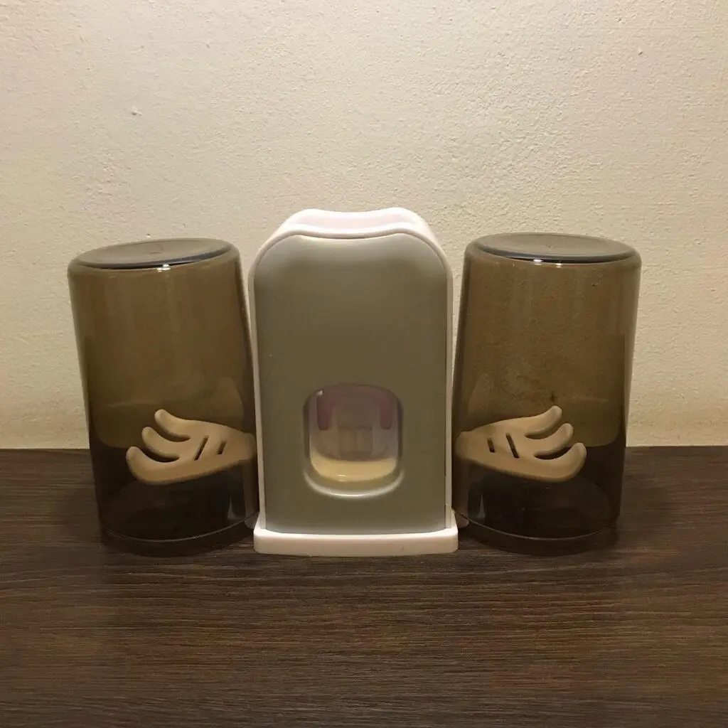 Soporte doble para cepillos de dientes y dispensador de pasta, diseño moderno.