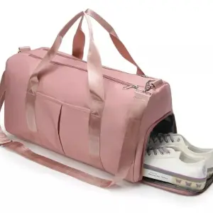 Bolso de viaje o gym impermeable rosa con compartimento para zapatos y zapatillas blancas.