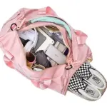 Maleta impermeable de gimnasio color rosa con zapatillas de cuadros, audífonos y accesorios.