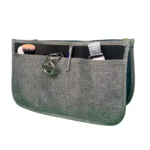 Organizador de bolso gris para dama con brocha, pluma y gel antibacterial.