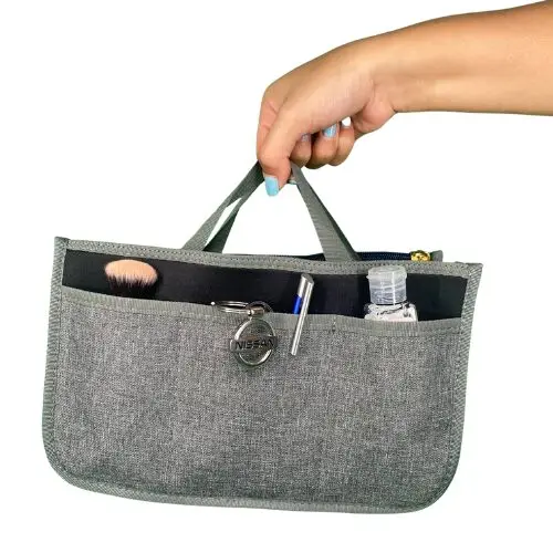 Organizador de bolso gris para dama con cepillo, bolígrafo, llaves y desinfectante.