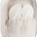 Bolso de viaje beige con malla transparente y dos chancletas blancas en su interior.