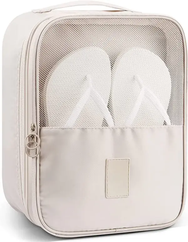 Bolso de viaje beige con malla transparente y dos chancletas blancas en su interior.