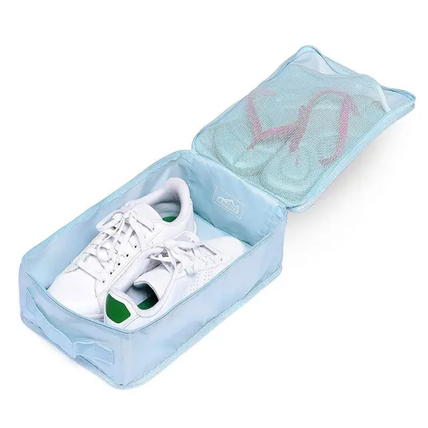 Bolso de viaje para zapatos y ropa, muestra zapatillas blancas en compartimento inferior y chanclas rosas en superior.