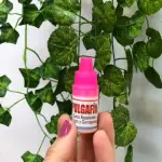 Pulgafin Gotas Repelentes contra Pulgas y Garrapatas para Mascotas en mano con fondo de hojas verdes.
