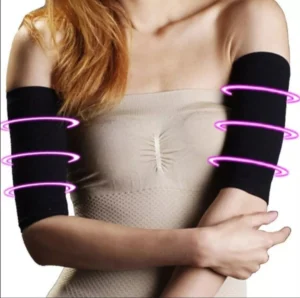 Manga adelgazante de brazo negra con bandas rosas, vista frontal de mujer en top beige.