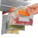 Estante organizador de nevera colgando bolsas con tomates, frijoles y maíz en un congelador.