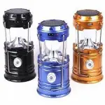 Lámpara linterna solar Sh-5800T negra, azul y dorada con asas plegables.