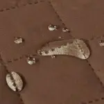 Cubre sofá de 2 puestos marrón con gotas de agua que demuestran su impermeabilidad.