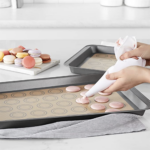 Tapete de silicona para hornear repostería con macarons rosados y pastelería.