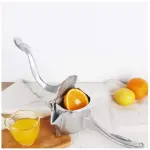 Exprimidor manual de aluminio para cítricos con naranja y limón, listo para jugo fresco.