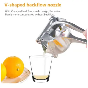 Exprimidor manual de frutas plateado extrayendo jugo de limón en un vaso.