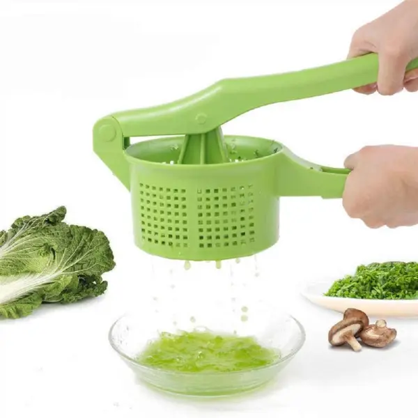 Exprimidor escurridor de cocina verde aplastando verduras para jugo fresco, con repollo y champiñones.
