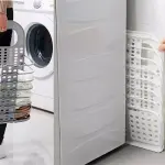 Cesta plegable multiusos gris para ropa, junto a lavadora y cesta blanca expandida.