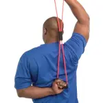 Hombre realiza estiramiento de tríceps con Theratubo elástico con agarraderas.