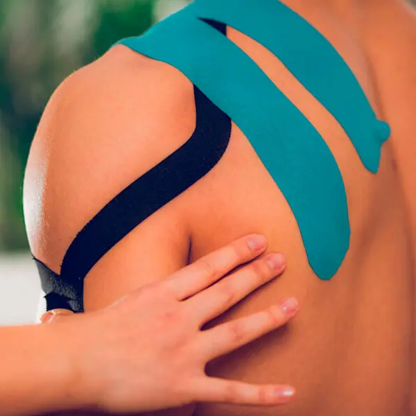 Cinta kinesiologica neuromuscular aplicada en hombro de persona en primer plano.
