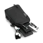 Bolso pechero negro con smartphone, cartera, gafas de sol y llaves de coche.
