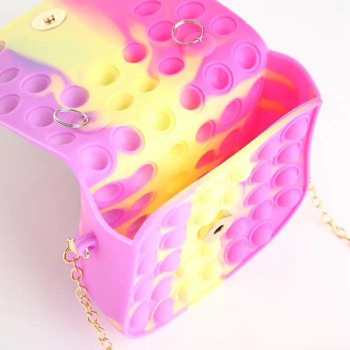Bolso infantil tipo "Pop It" en colores fucsia y amarillo con cadena dorada.
