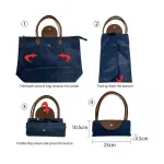 Bolso cartera plegable azul con asas marrones, cerrado y con medidas.