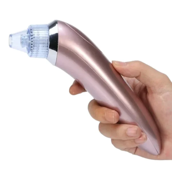 Extractor de puntos negros y espinillas en tono rosa sostenido por una mano.