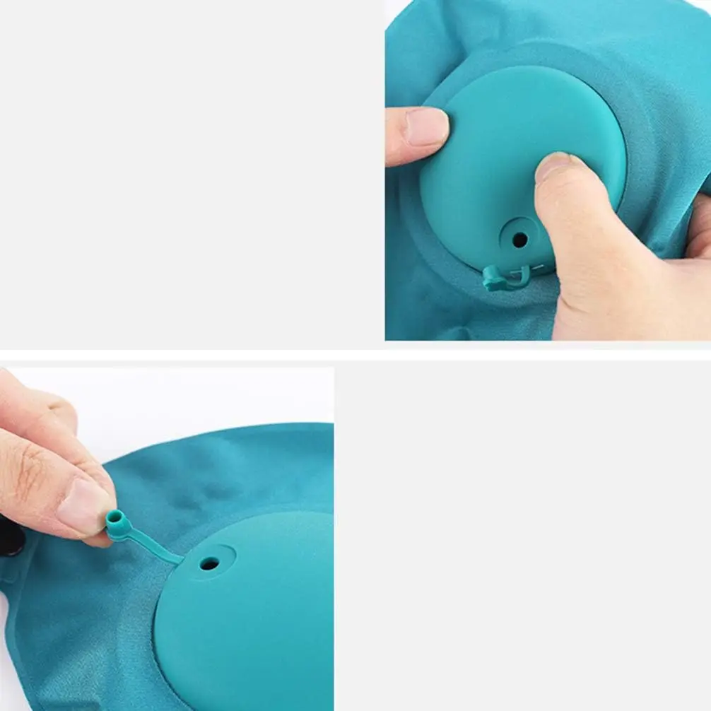 Almohada viajera azul con válvula de aire visible siendo manipulada por manos.