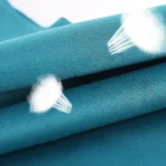 Almohada viajera de tejido transpirable color turquesa con efecto de ventilación.