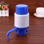 Bomba manual dispensador de agua para botellón azul y blanco con taza en fondo de madera.