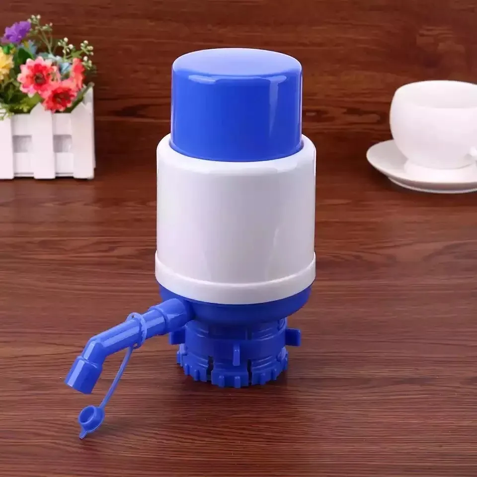 Bomba manual dispensador de agua para botellón azul y blanco con taza en fondo de madera.