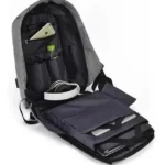 Morral antirrobo gris abierto con celular dorado, audífonos, botella y portátil visible en compartimentos.