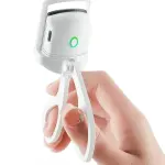 Rizador de pestañas eléctrico blanco sostenido por una mano, con círculo verde encendido.