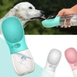 Bebedero portátil para mascotas: perro blanco bebiendo agua de un dispensador azul turquesa.