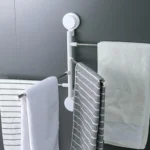 Soporte para toallas giratorio con ventosas y tres toallas de diferentes texturas colgadas.