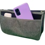 Organizador de bolso gris para dama con bolsillo frontal que contiene un celular morado y audífonos blancos.