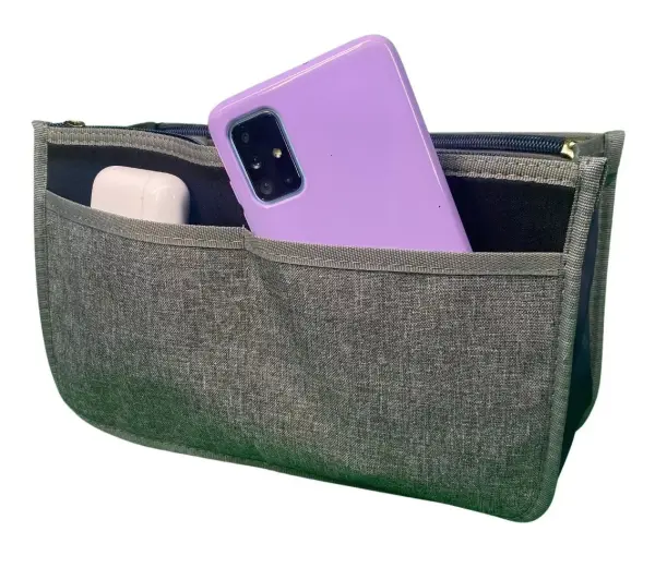Organizador de bolso gris para dama con bolsillo frontal que contiene un celular morado y audífonos blancos.