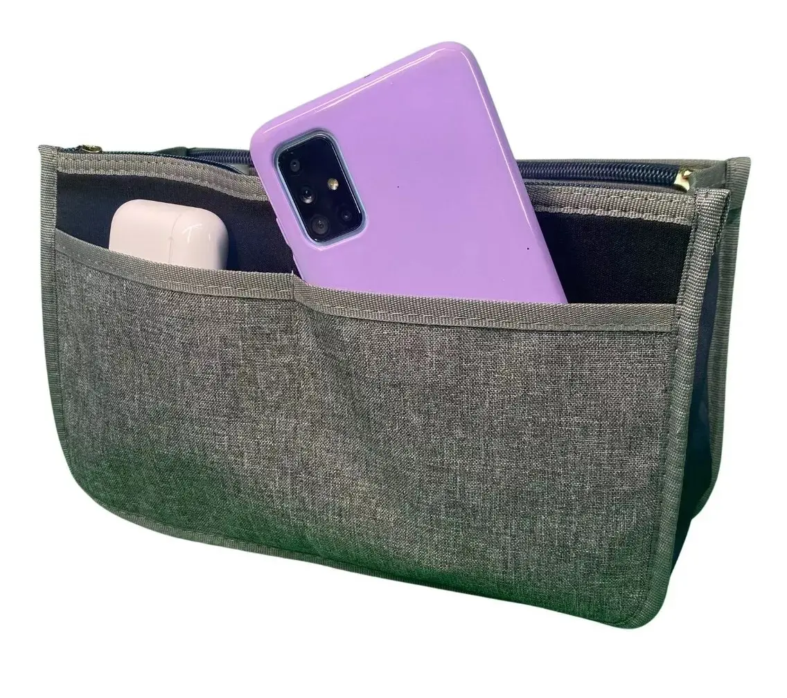Organizador de bolso gris para dama con bolsillo frontal que contiene un celular morado y audífonos blancos.