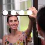 Tira de 4 bombillos LED Studio Glow en espejo, ideal para maquillaje y belleza.
