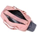 Bolso de viaje o gym impermeable rosa, abierto con compartimentos internos visibles.