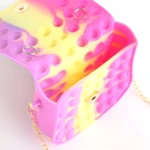 Bolso para niña estilo Pop It con diseño divertido en fucsia y amarillo.