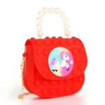 Bolso pop it rojo para niña con diseño de unicornio y asa de perlas.