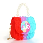 Bolso pop it infantil con unicornio arcoíris y asa de perlas, ideal para niñas.