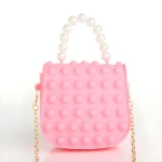 Bolso infantil rosa estilo Pop It con asa de perlas y cadena dorada.