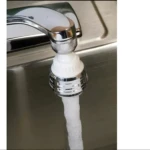 Cabezal ahorrador de agua ajustable para grifo en acción sobre un lavaplatos de acero inoxidable.