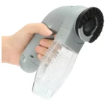 Cepillo aspiradora quita pelo para mascotas en mano, recolecta pelusa eficientemente.