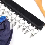 Colgador de gorras con pinzas metálicas para organizar accesorios de moda.